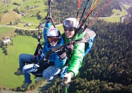 Tandem Paragliding from Unterberghorn for Kids (up to 14 y.) Airtaxi Kössen Cover A child and instructor flying through the air during Tandem Paragliding from Unterberghorn for Kids (up to 14 y.) Airtaxi Kössen.