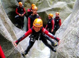 Ein junger Teilnehmer klettert zwischen 2 Felsen beim Canyoning in der Zemmschlucht für sportliche Familien mit Actionclub Zillertal.
