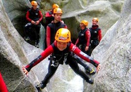 A young participant climbs between 2 rocks while canyoning in the Zemm Gorge for sporty families with Actionclub Zillertal.