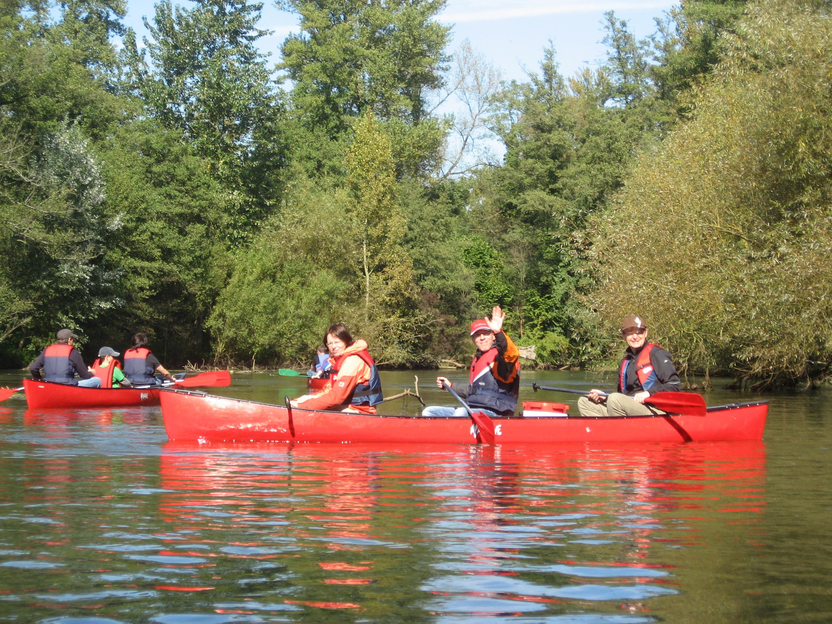 People cheering at the camera during the Canoe Tour on the Elz with Black Forest Magic Outdoorschule.