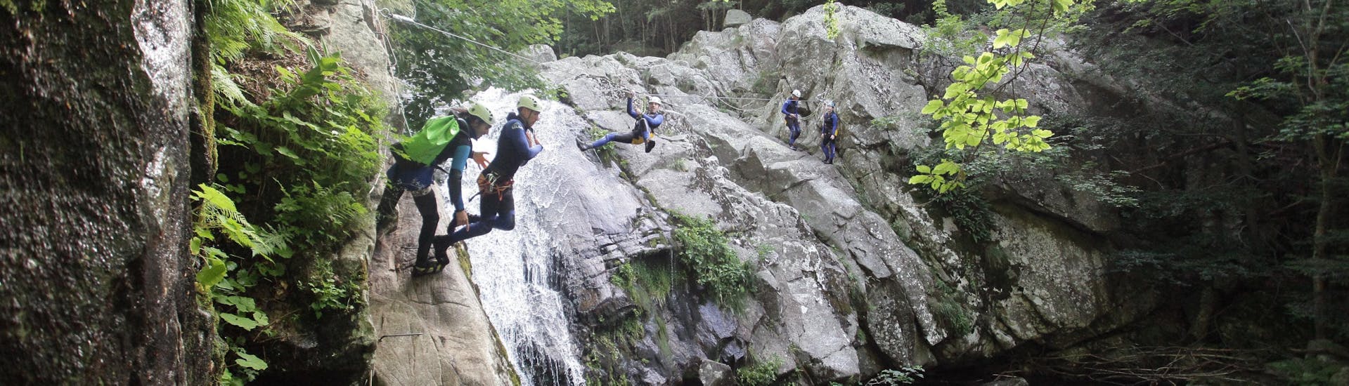 Los amigos están superando diferentes obstáculos, incluida una tirolina y saltos, durante su barranquismo clásico en el Cañón Aéro Besorgues, con Geo Ardèche Canyon.