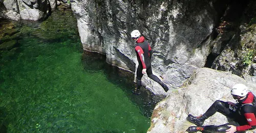 Canyoning Classico nel Canyon dell'Aéro Besorgues nell'Ardèche con GEO Ardèche Canyon Un uomo mentre salta in una piscina color smeraldio, durante il Torrentismo classico nel Canyon dell'Aéro Besorgues a Ardèche con Geo Ardèche Canyon.