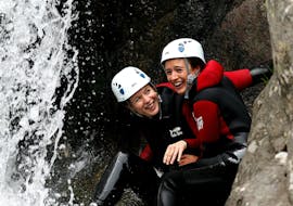 Dos amigos se divierten bajo una cascada durante su barranquismo en el Cañón de la Haute Besorgues, con Geo Ardèche Canyon.