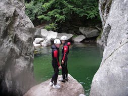 Twee vrienden maken zich klaar om in een smaragdgroen zwembad te springen tijdens hun Aquatic Canyoning in Canyon de la Borne met Geo Ardèche Canyon.