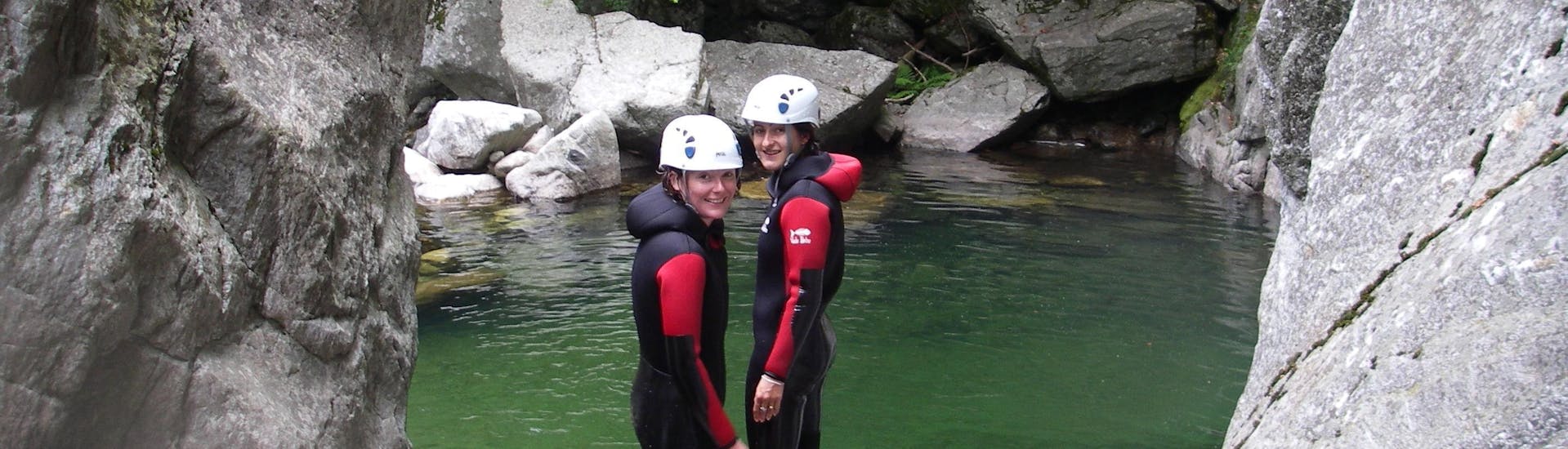 Dos amigos se preparan para tirarse a una piscina esmeralda durante su barranquismo acuático en el Cañón de la Borne, con Geo Ardèche Canyon.