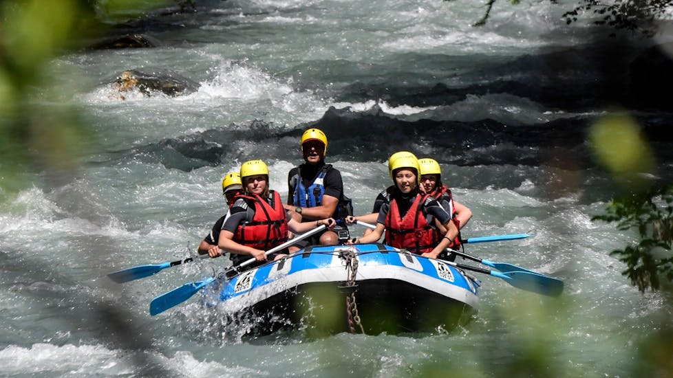 A group of friends is paddling on the Guisane River during their rafting tour for kids (8-12 years) with Rivieres Evasion.