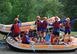 Kids are standing on a raft ready to start their Rafting on the Guisane River for Kids (8-12 years) with Rivieres Evasion.