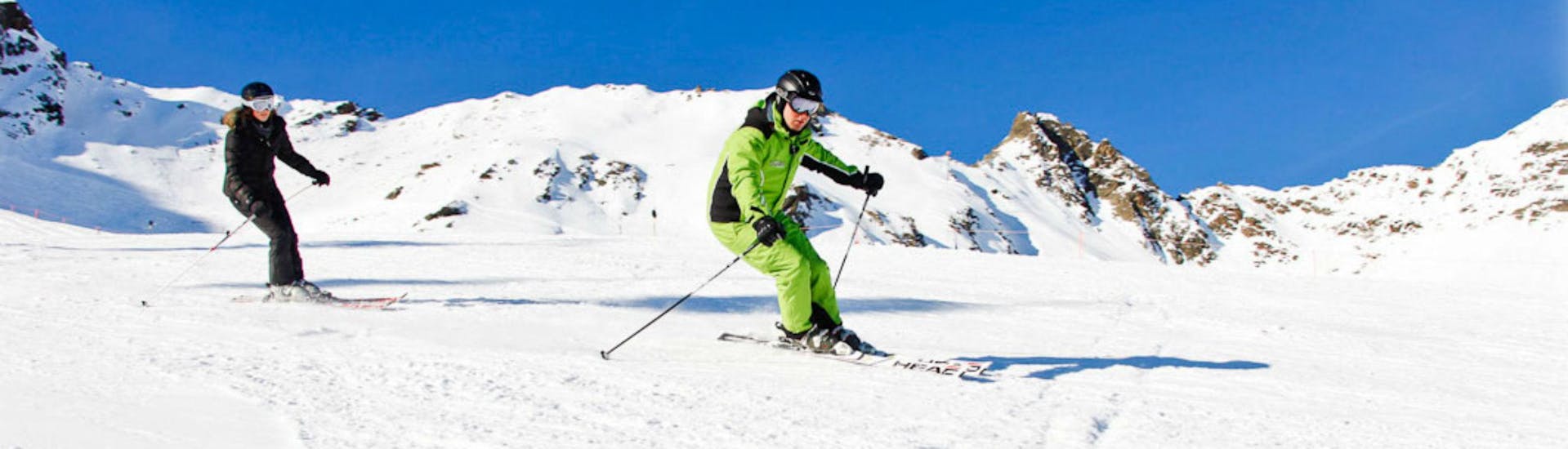 A female skier is following her ski instructor from the ski school Ski- und Bikeschule Ötztal Sölden during her Private Ski Lessons for Kids & Adults - All Levels.