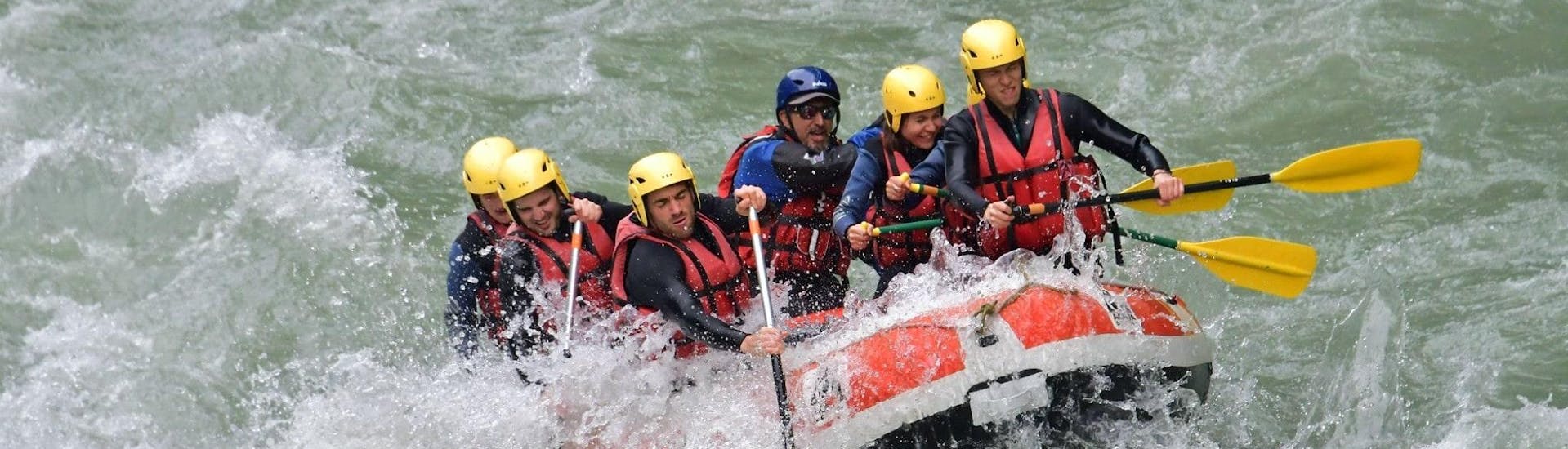 Un gruppo di amici sta affrontando alcune rapide sul fiume Dranse durante il giro di rafting di scoperta con 7 Aventures Savoie.