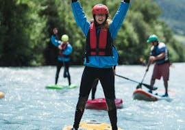 Ein junges Mädchen ist begeistert von der Teilnahme am Stand Up Paddling auf der Etsch im Vinschgau - Flusstour mit Adventure Südtirol.