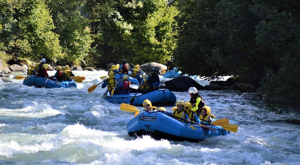 Some rafts of the Rafting Colorado Enjoy are conquering the rapids of the river during the activity organized by X Raft Val di Sole.
