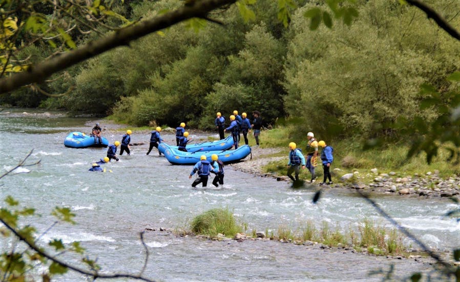 The participants of the Rafting Super integral on the river Noce organized by X Raft Val di Sole are going out from the river at the end of the activity.