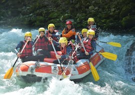 A family is tackling some rapids on the Dranse river during their discovery rafting tour with 7 Aventures.