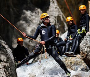 A guide from SerreChe Canyon is showing the participants how to handle an abseiling passage during their Canyoning in Canyon du Fournel - Discovery tour.