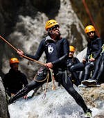 A guide from SerreChe Canyon is showing the participants how to handle an abseiling passage during their Canyoning in Canyon du Fournel - Discovery tour.