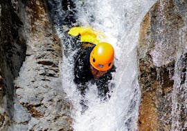 A man is sliding down a natural slide head first during his Canyoning in Canyon des Acles - Dynamic tour with SerreChe Canyon.
