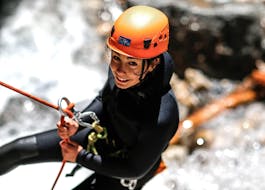 A woman is tackling an abseiling passage during her Canyoning in Canyon du Foresto - Italian Adventure tour with SerreChe Canyon.