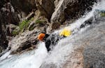 Un homme descend un toboggan naturel la tête la première lors d'une sortie Canyoning dans le caynon de Caprie - Aventure Italie avec SerreChe Canyon.