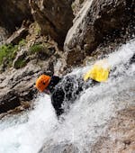 A man is sliding down a natural slide head first during his Canyoning in Canyon de Caprie - Italian Adventure tour with SerreChe Canyon.