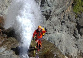 Un homme prend une photo après avoir réussi à descendre en rappel une cascade lors de sa sortie Canyoning dans le canyon du Chichin - Expert avec SerreChe Canyon.