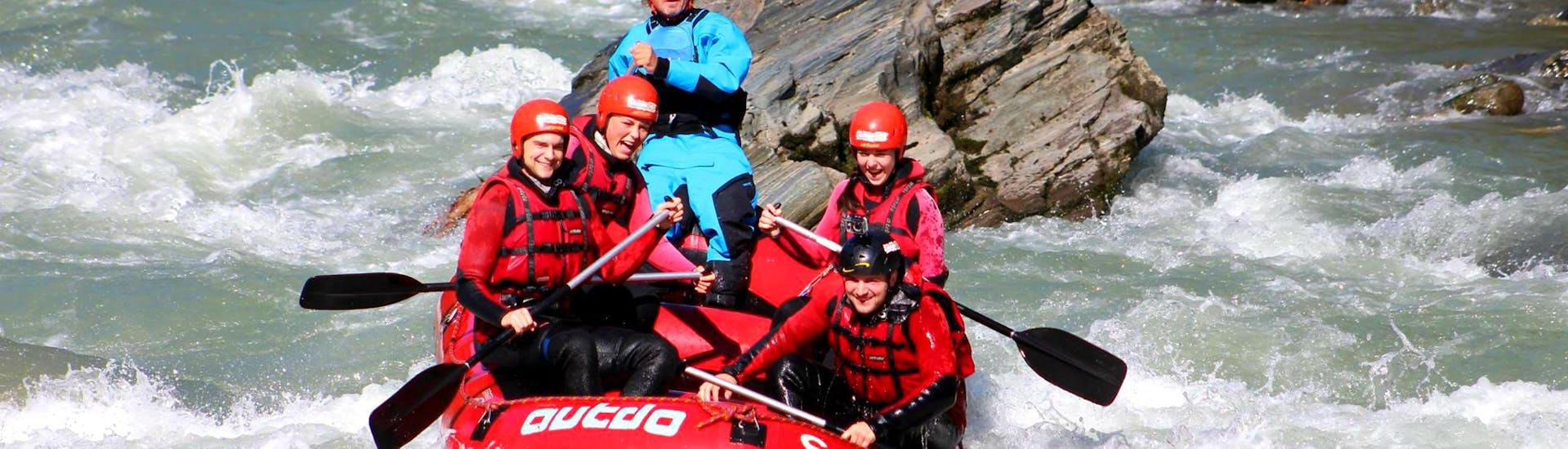 Een raftinggroep die samen met een ervaren gids van Outdo Zell am See Rating & Canyoning de golven en stroomversnellingen van de rivier de Salzach bedwingt tijdens hun Rafting Tour "Wild Water".
