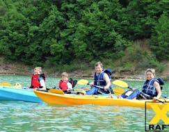 Eine Familie lächelt bei der von X Raft Val di Sole organisierten Kayak Tour für Familien auf dem Santa Guistina See in die Kamera.