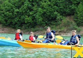 Eine Familie lächelt bei der von X Raft Val di Sole organisierten Kayak Tour für Familien auf dem Santa Guistina See in die Kamera.