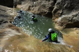 A group in a natural slide during canyoning in the Riolan canyon in summer.