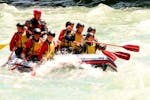 A raft with a team of 8 people is going down the Adda during the Rafting on the Adda - Full Fun of Rafting Lombardia.