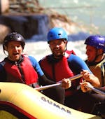 A raft with a team of 4 people is going down the Adda during the Rafting on the Adda - Full Wine of Rafting Lombardia.
