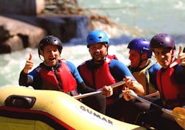 A raft with a team of 4 people is going down the Adda during the Rafting on the Adda - Full Wine of Rafting Lombardia.
