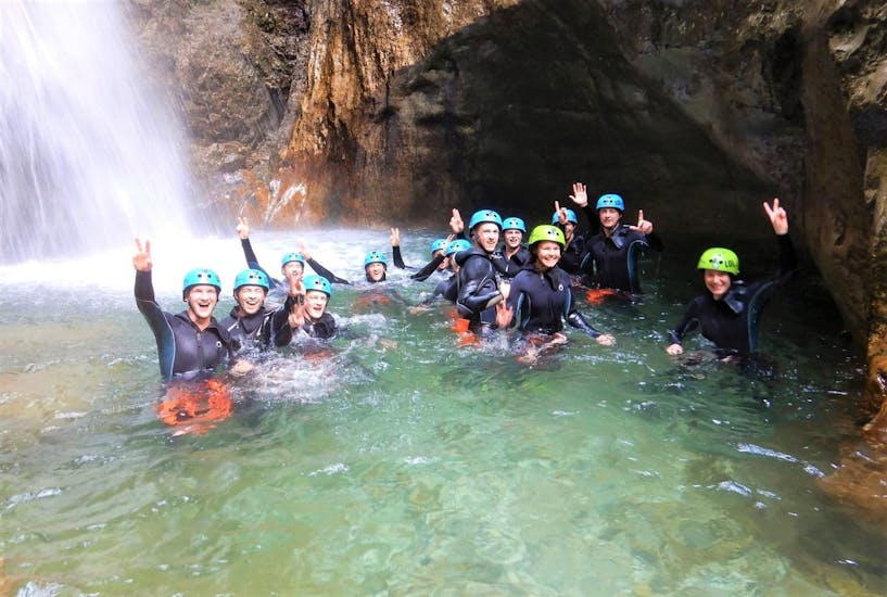 Een groep deelnemers van de activiteit Canyoning in Rio Nero - Classic georganiseerd door LOLgarda lacht in het water van de canyon bij het Gardameer.