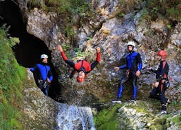 Groepsfoto met een man die ondersteboven hangt tijdens de canyoning trip met OUTdoor Slovenia Bled.