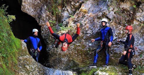 Canyoning in de Grmecica-kloof vanuit Bled met OUTdoor Slovenia Bled Groepsfoto met een man die ondersteboven hangt tijdens de canyoning trip met OUTdoor Slovenia Bled.