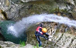 A participant of the Canyoning in Torrente Tignale is slowly abseiling down a rock during the activity organized by LOLgarda.