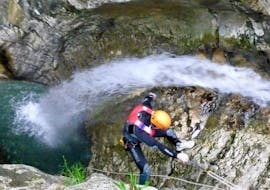 Un partecipante dell'attività Canyoning nel Torrente Tignale si sta calando con una corda nelle gole del torrente Tignale durante l'attività organizzata da LOLgarda.