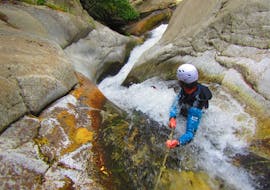 A person is doing a abseiling during his Canyoning in Canyon du Cady - Aquatic activity with Extérieur Nature.