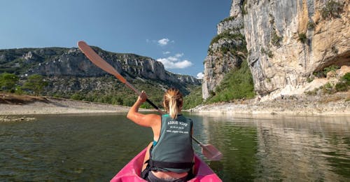 13km Kayak & Canoe Hire in Ardèche - Swim & Sun Having rented a high-quality canoe at Aigue Vive, a woman is enjoying canoeing during the tour "Swim & Sun - 13km" in Ardèche.