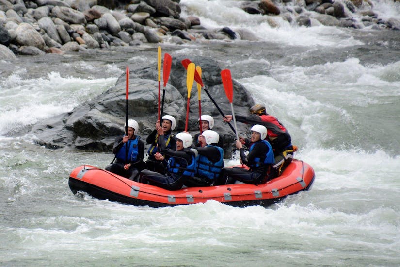 View of a group of people  having fun on a rafting boat in the lively white waters of the Sesia river during the Rafting on the Sesia with Centro Canoa e Rafting Monrosa.
