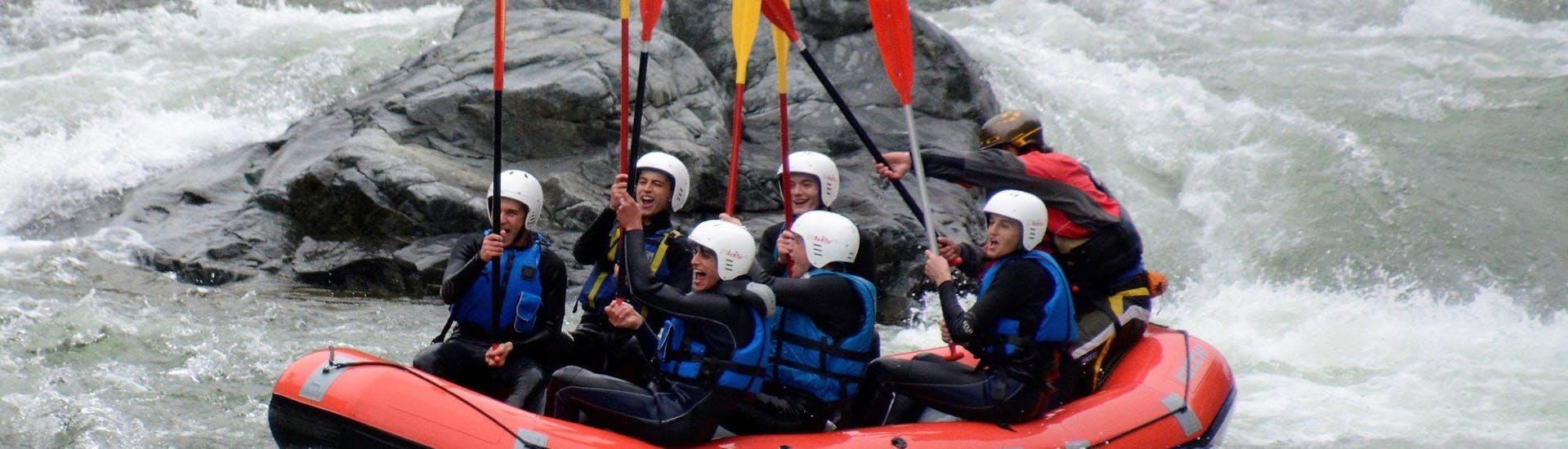 Vista di un gruppo di persone che si divertono su un gommone da rafting nelle vivaci acque bianche del fiume Sesia durante il Rafting sul Sesia con il Centro Canoa e Rafting Monrosa.