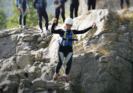A woman is jumping from a rock with canyoning equipment on during the Canyoning in the Sorba River with Centro Canoa e Rafting Monrosa.