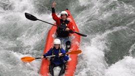 Due persone su un mini-raft scendono una rapida mentre ridono durante il Mini-Raft sul Sesia con il Centro Canoa e Rafting Monrosa.