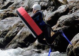 Woman having fun while jumping from a rock with hydrospeed equipment during the Hydrospeed on the Sesia with Centro Canoa e Rafting Monrosa.