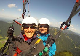 A women is smiling into the camera during the tandem paragliding in the bavarian alps with Paraworth.