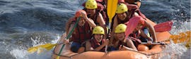 A group is smiling for the photo on their raft during the activity Rafting adventure on the Garonne with H2O vives.