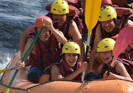 Adventurous Rafting on the Garonne River with H2O Vives Pyrenees A group is smiling for the photo on their raft during the activity Rafting adventure on the Garonne with H2O vives.
