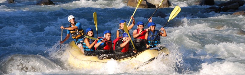 Participants cheering at the camera during the rafting on the Adda River - Adrenaline with Indomita Valtellina River.