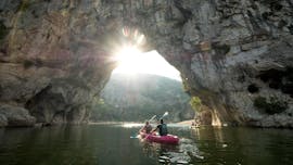 En el recorrido "Maxi-Discovery 13km" en Ardèche, una pareja pasa bajo el famoso arco Pont d'Arc sentados en una canoa de alta calidad, alquilada en Aigue Vive.