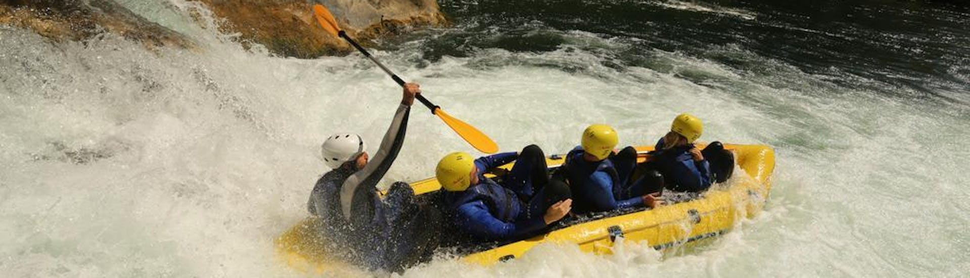 Friends and a guide sit in the raft and go down a fast rapid on the river during rafting on the Iller for stag parties (from 10 people) with MB Events & Adventures Allgäu & Bodensee.