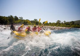 Eine Gruppe von Freunden sitzen im Raft und raften den Fluss hinab beim Rafting auf der Iller für Junggesellenabschiede (ab 10 Personen) mit MB Events & Adventures Allgäu & Bodensee.